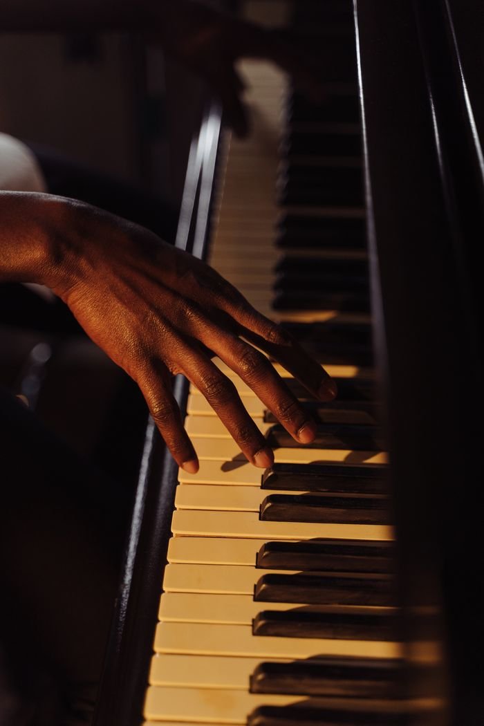 Artistic close-up image of a hand playing piano keys, capturing the essence of musical expression.